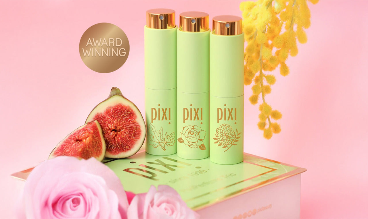 Award Winning: PixiPerfume Gift Trio shown on a pink background with plants - view 1