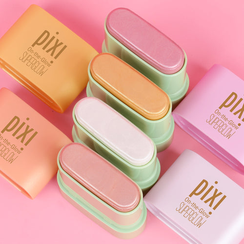 Six Pixi contour and highlight sticks in pastel shades of orange, peach, pink, mint green, white, and lavender, arranged diagonally on a solid pink background. view 2