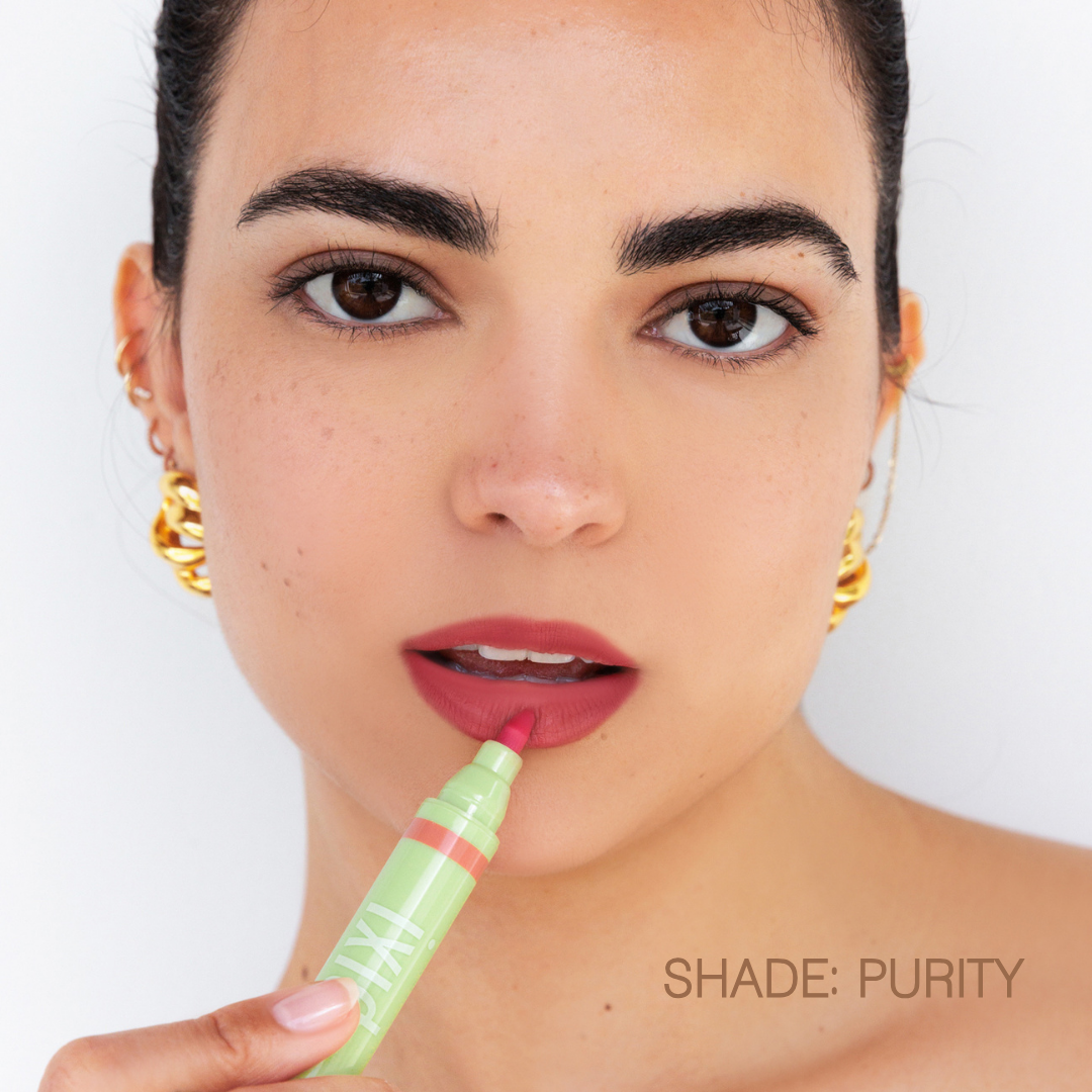 Woman applying LipBlush in shade Purity on a white background