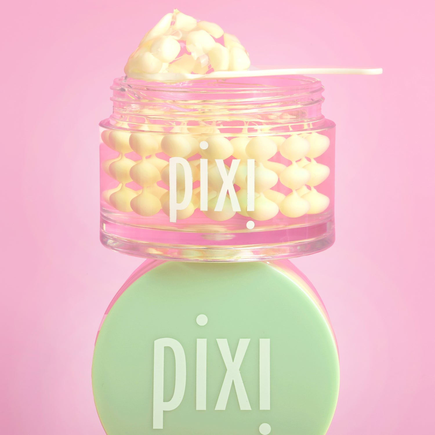 Pixi Vitamin-C CreamSerum product with pink lid and green cap on a pink background